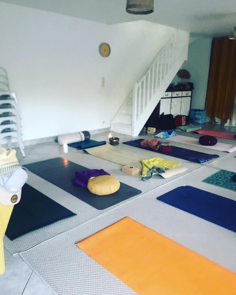 Photo de l'espace intérieur dédié au yoga et à la méditation illustrant l'emplacement des tapis et des accessoires pour le yoga
